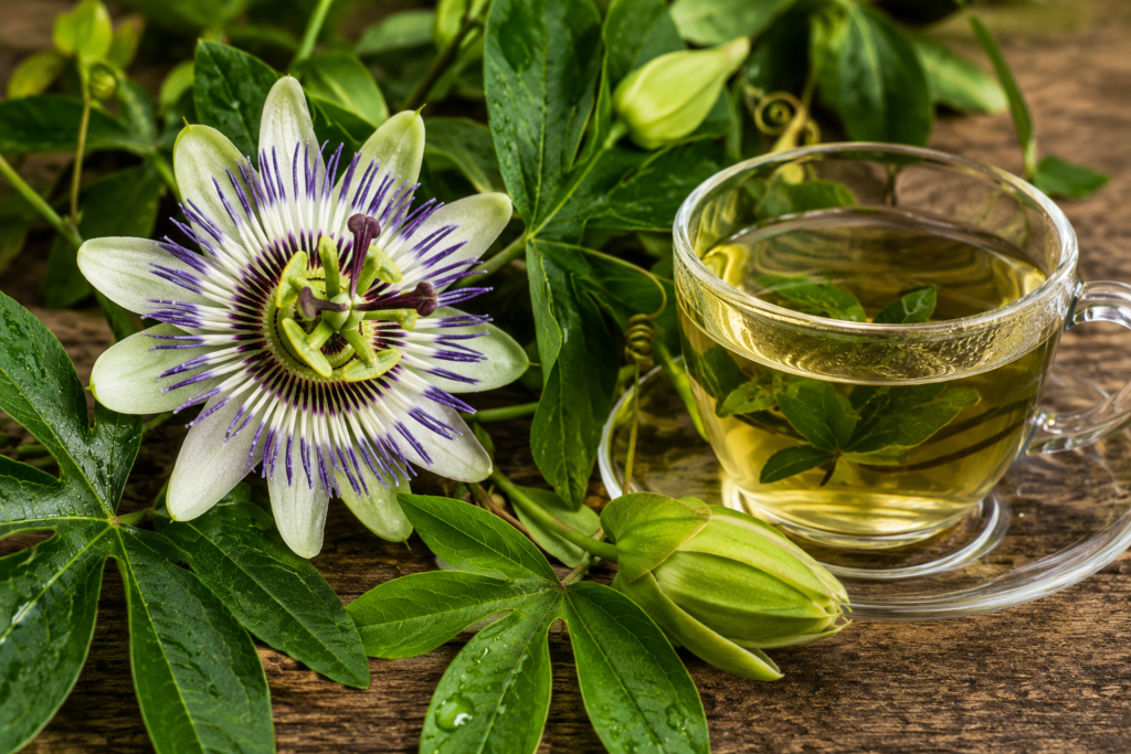 xícara de chá de passiflora com flor ao lado
